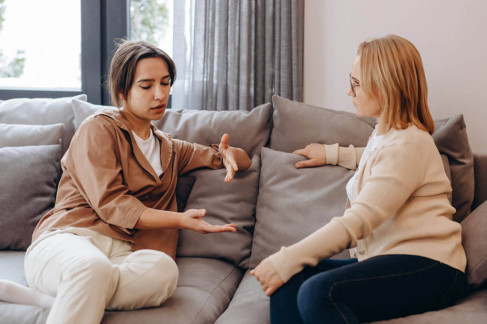 Two women discussing mental health at home